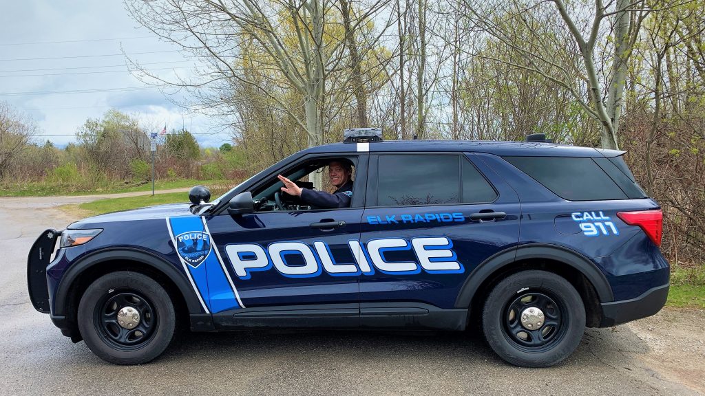Elk Rapids Police Chief waving from patrol car.